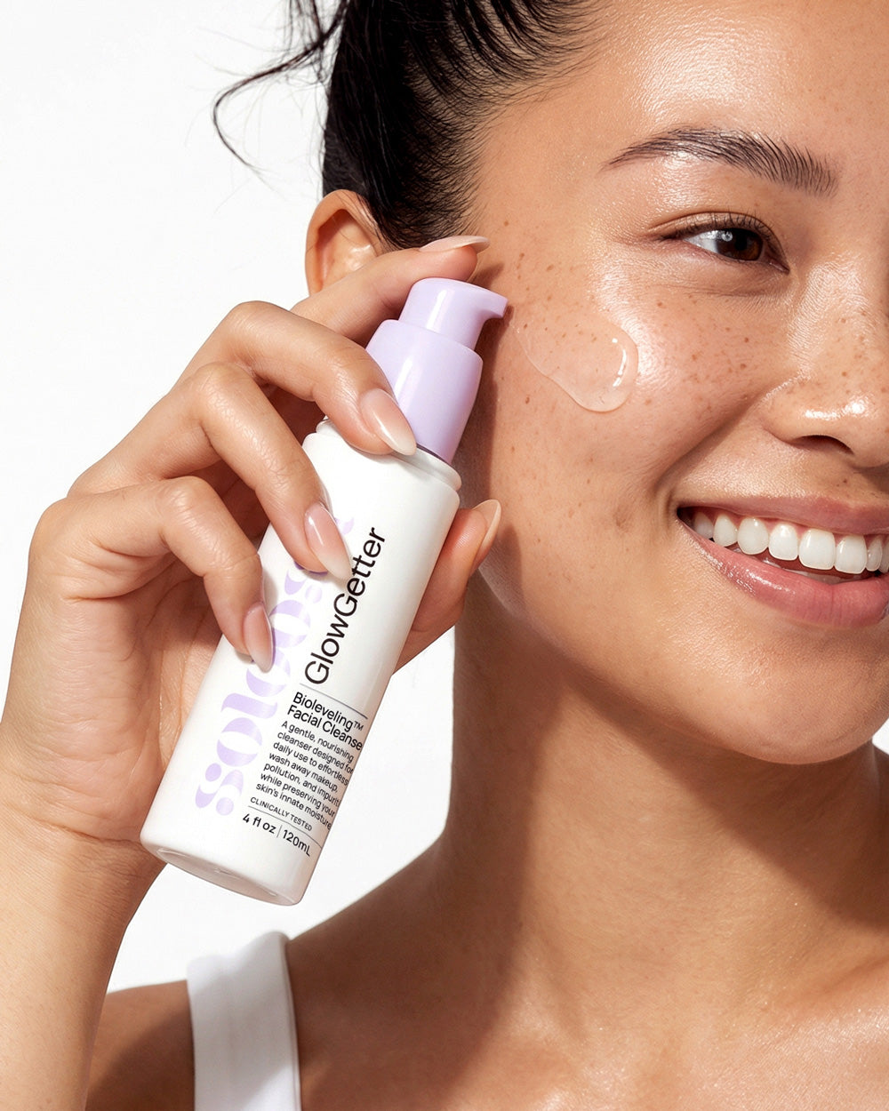 Asian girl applying GlowGetter Bioleveling Cleanser